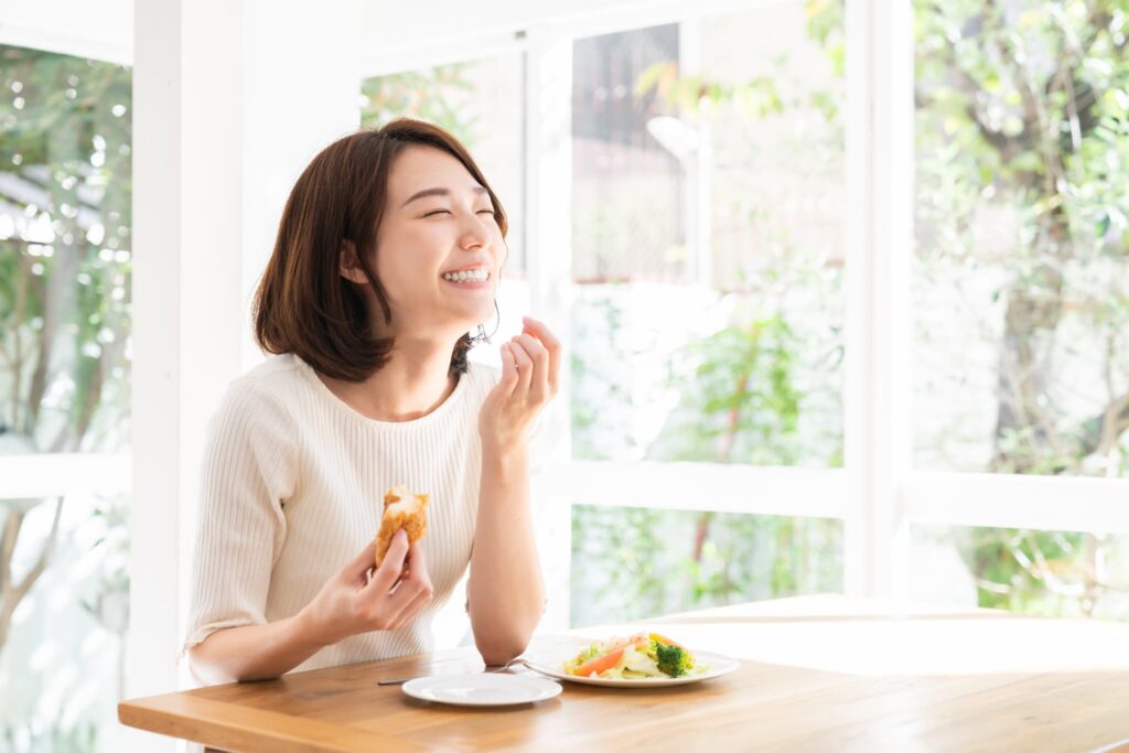 インプラント治療を終えて食事を楽しむ女性
