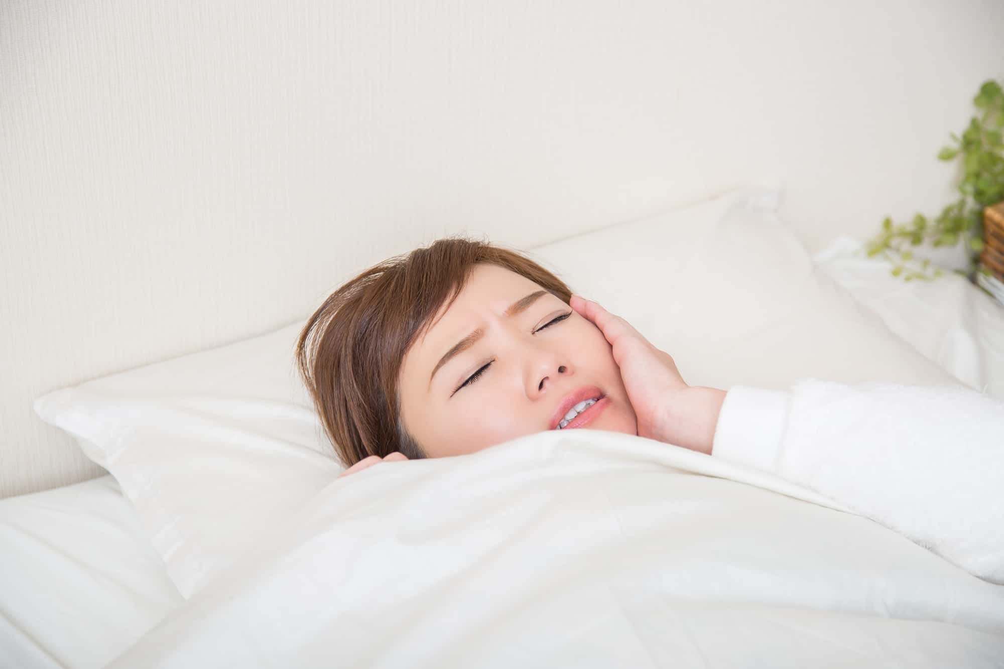 虫歯が痛くて眠れない女性