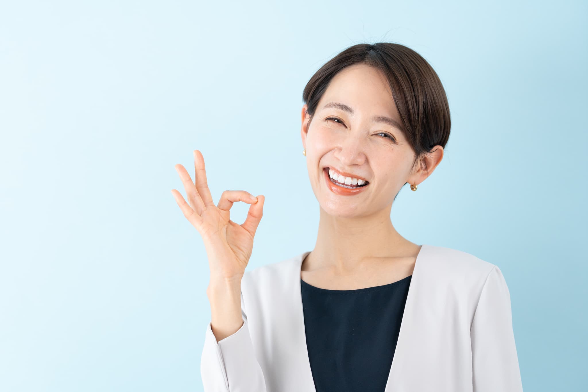 指でOKサインを出す女性
