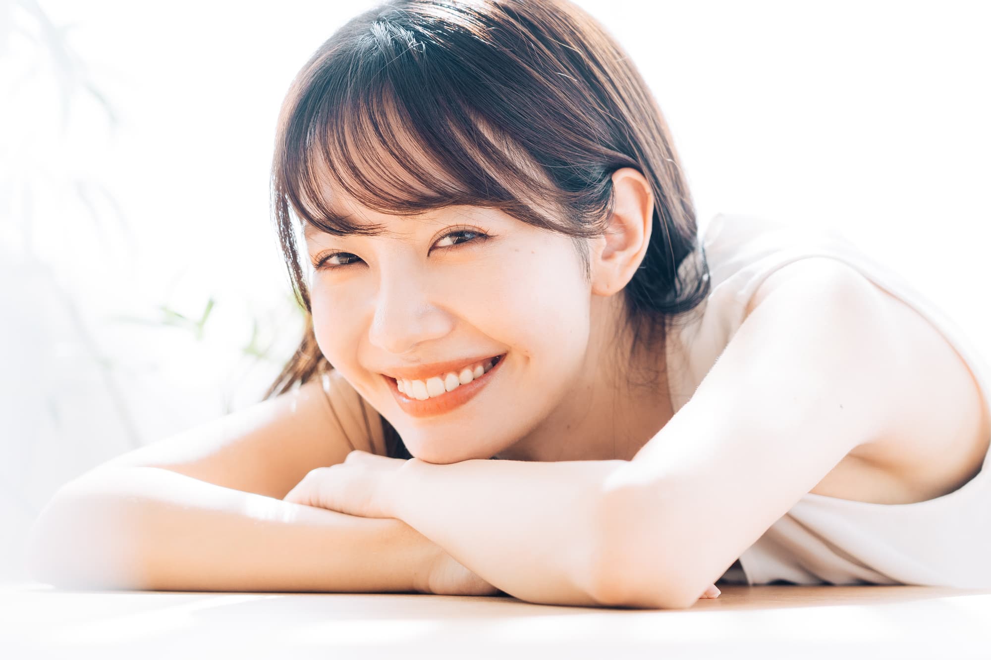 腕に顎を乗せ微笑む女性