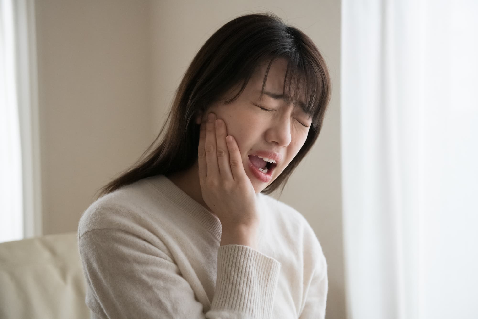 重度の虫歯になり強い痛みを感じる女性