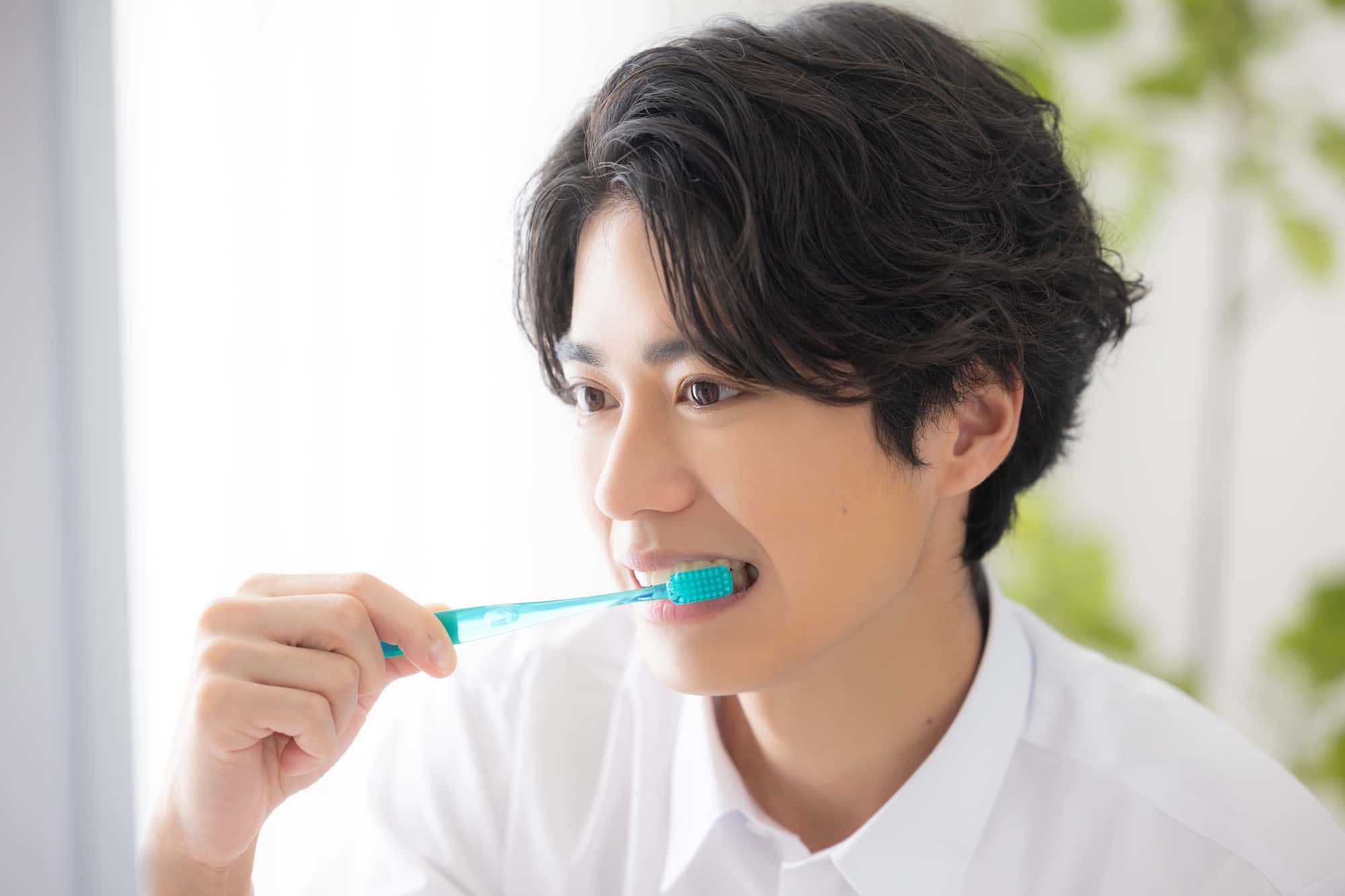 歯周病を予防する為に丁寧に歯みがきをする男性