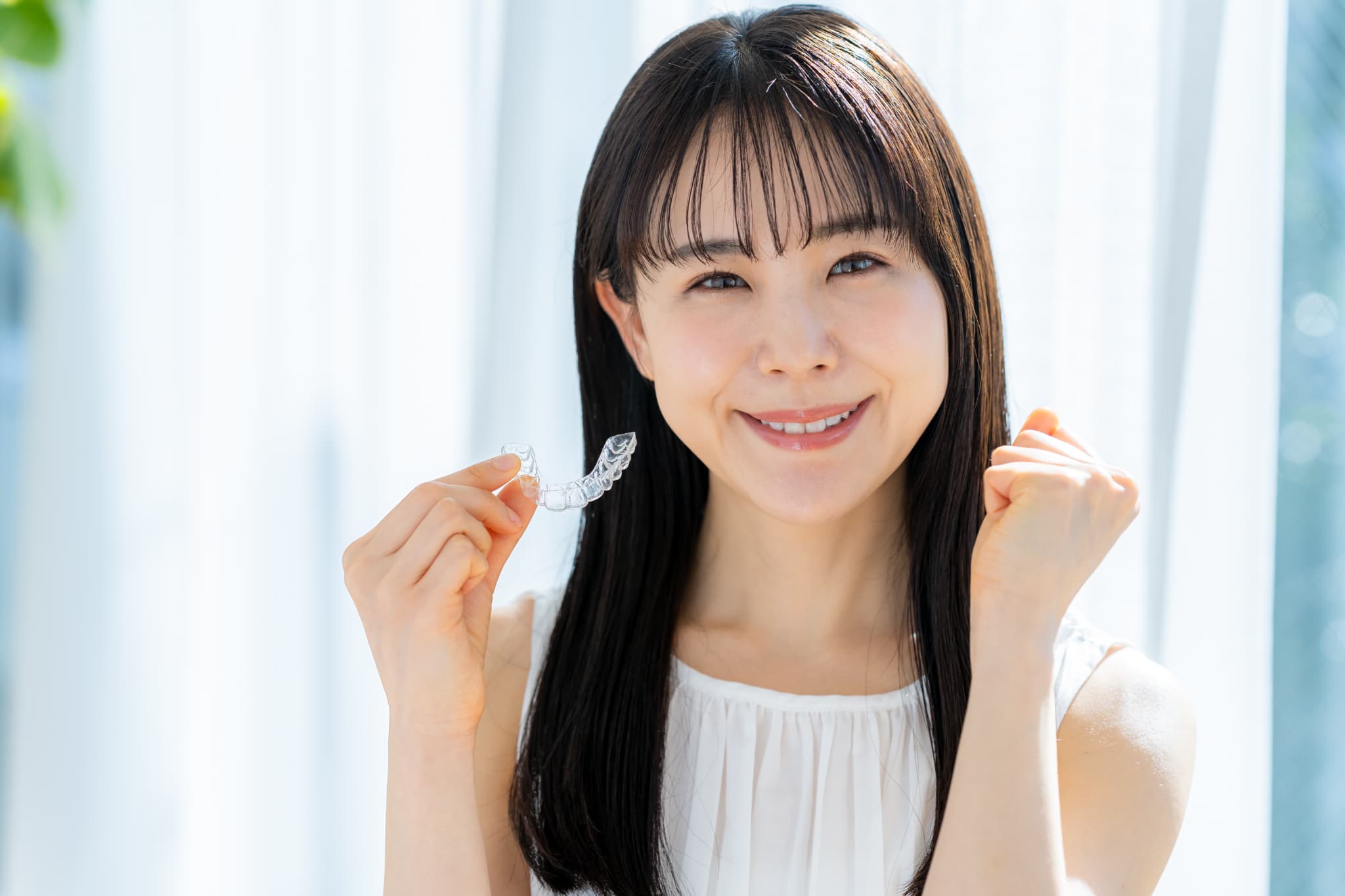インビザライン片手にガッツポーズする女性