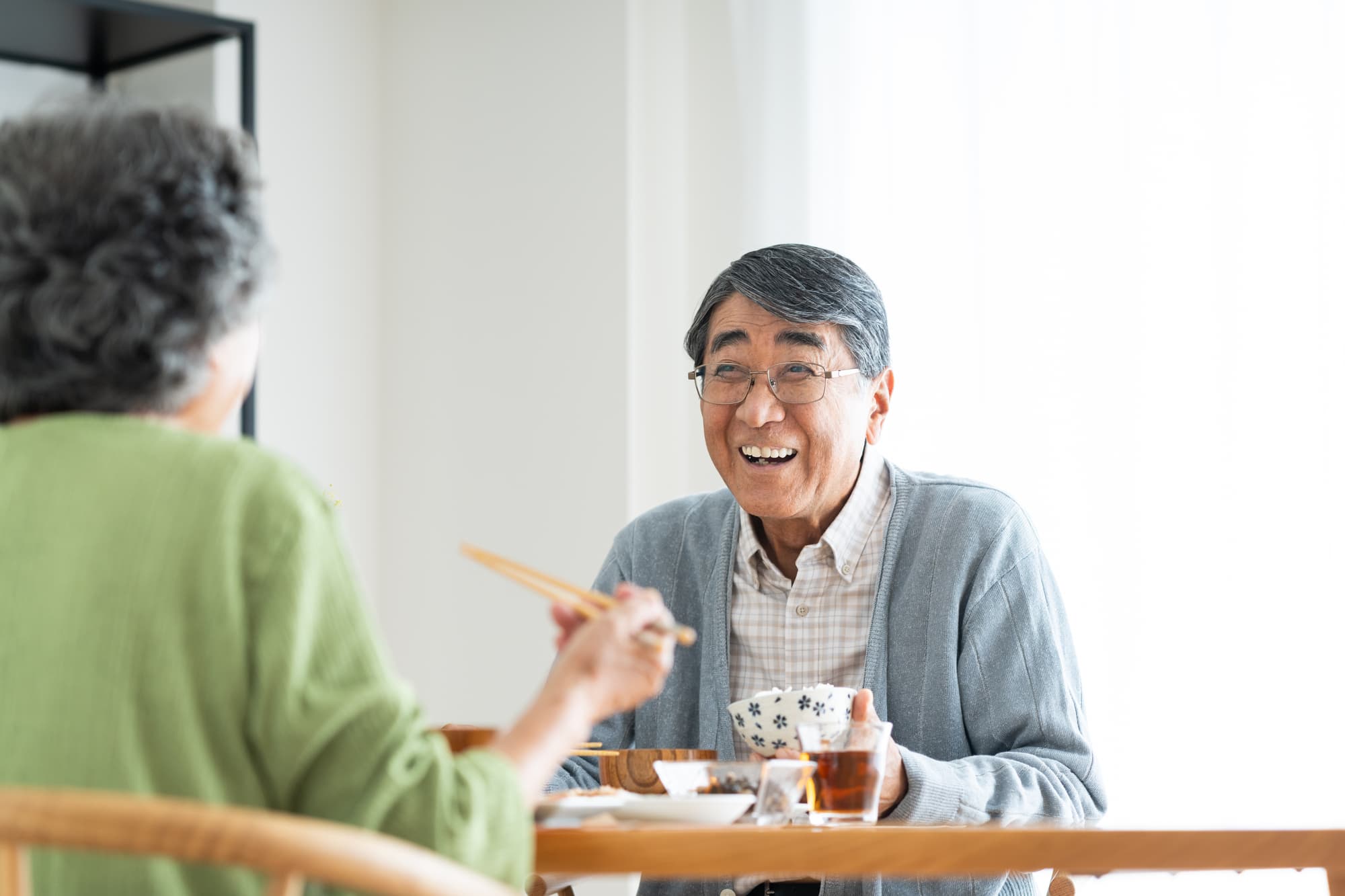 インプラント治療をして楽しく食事をする男性