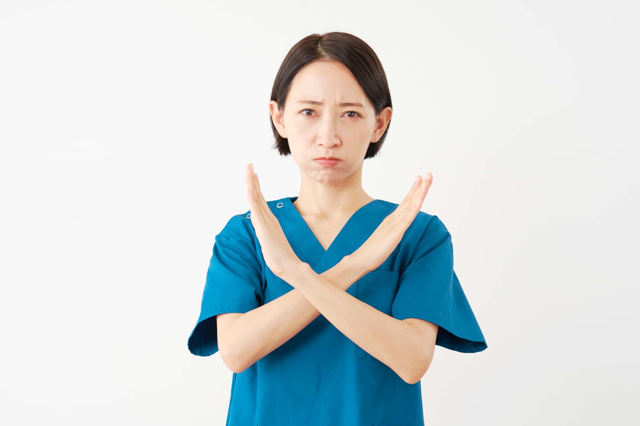 インプラント治療のやり直しができないと胸の前でバツをする歯科医