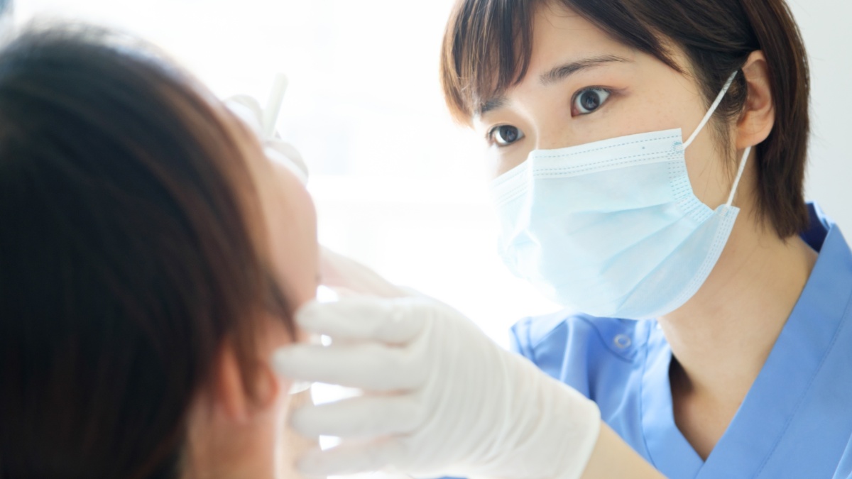 セラミックの歯が割れて歯科医に診てもらう患者