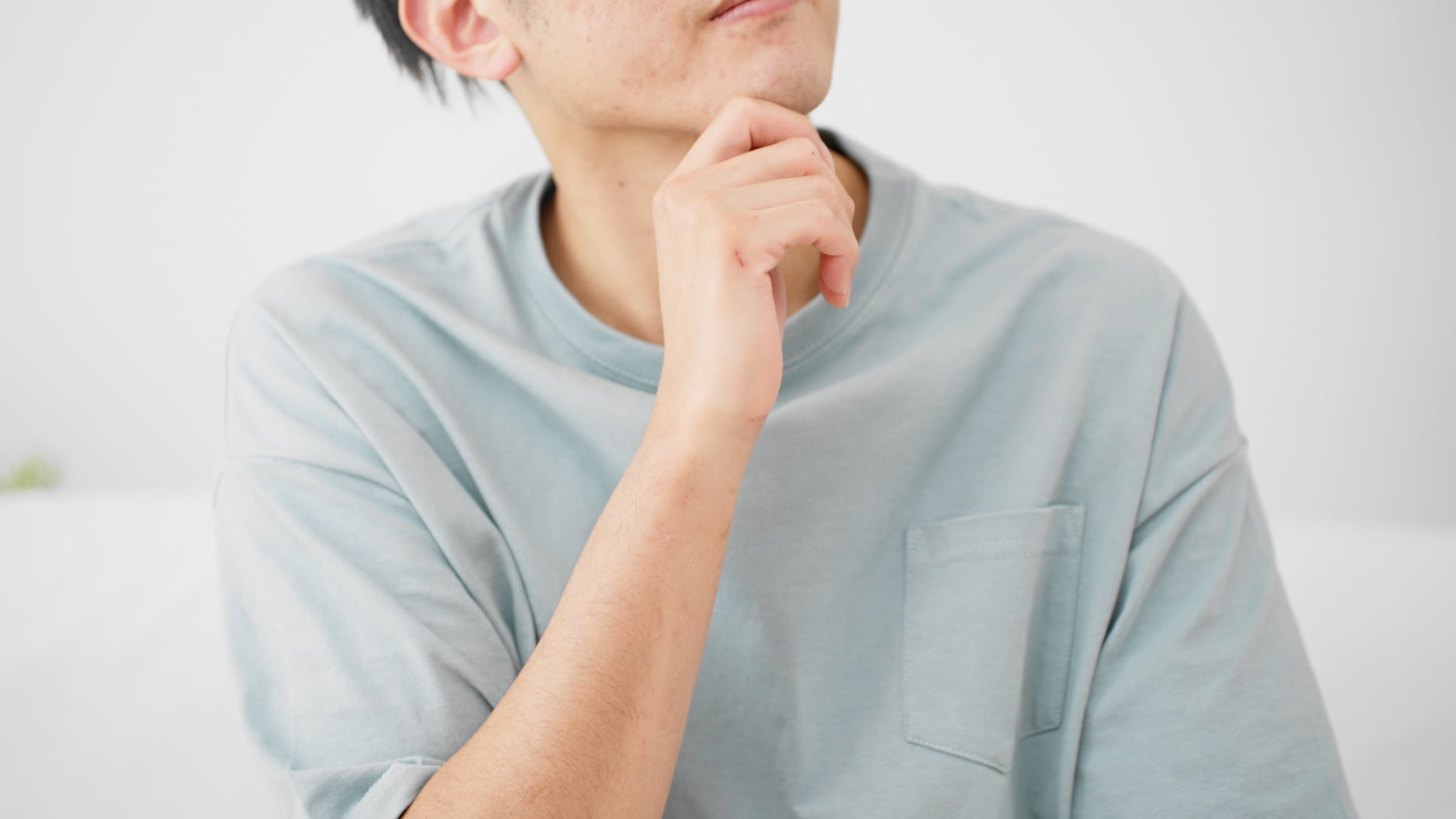 親知らずはいつ生えるのか考える若い男性